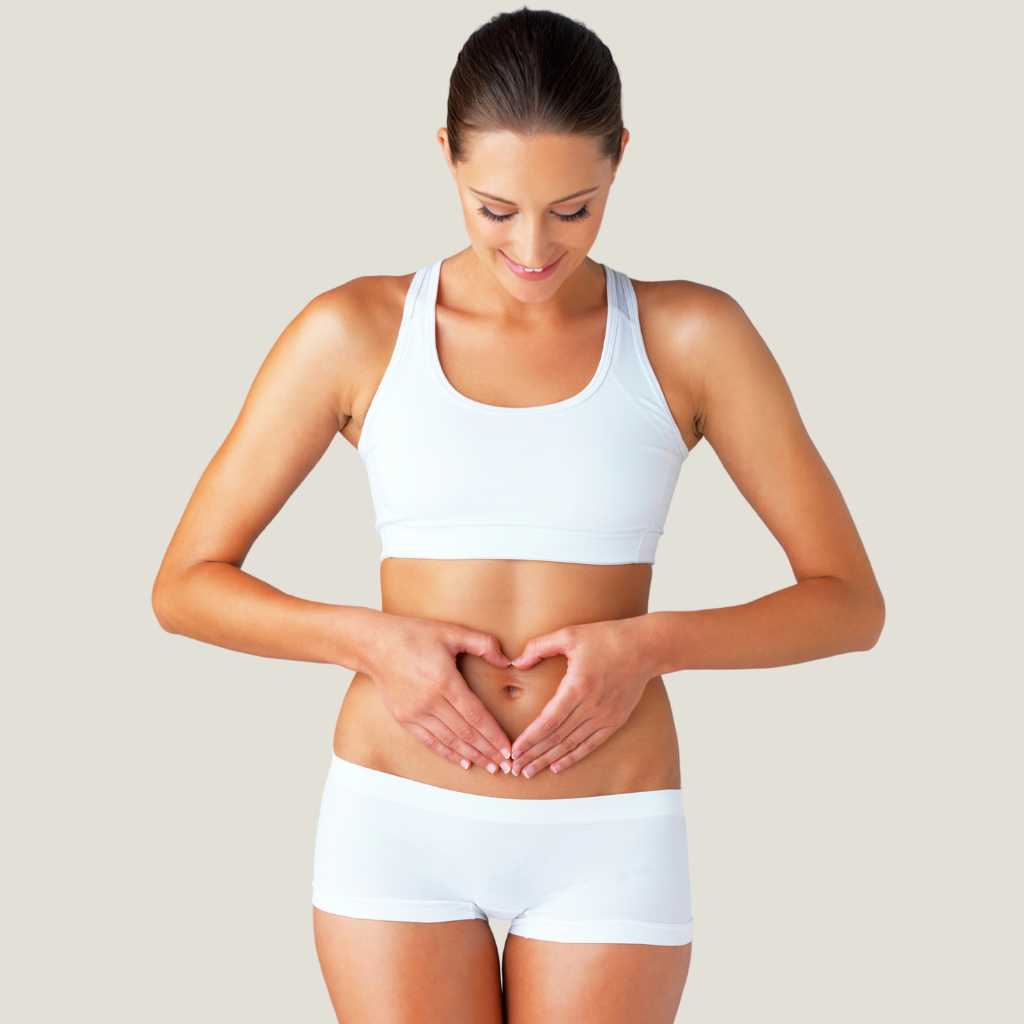 Mujer con las manos en el abdomen representando bienestar digestivo tras hidroterapia de colon